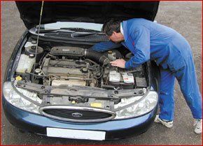 Man working on engine of car