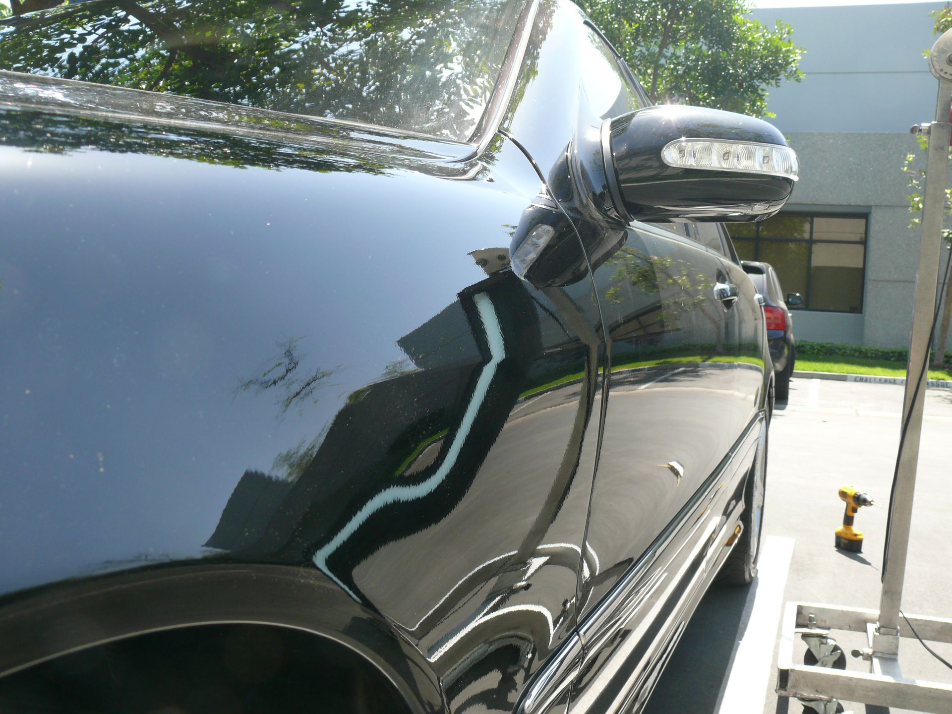 A black car is parked in front of a building