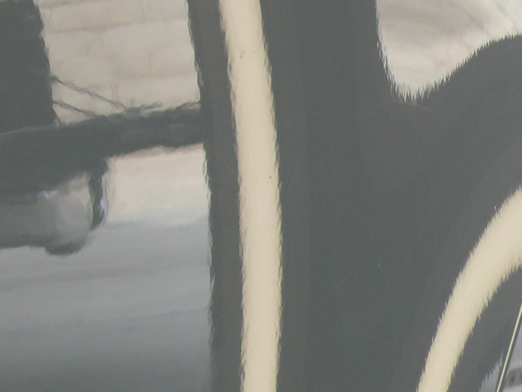 A close up of a black and white painting on a wall.