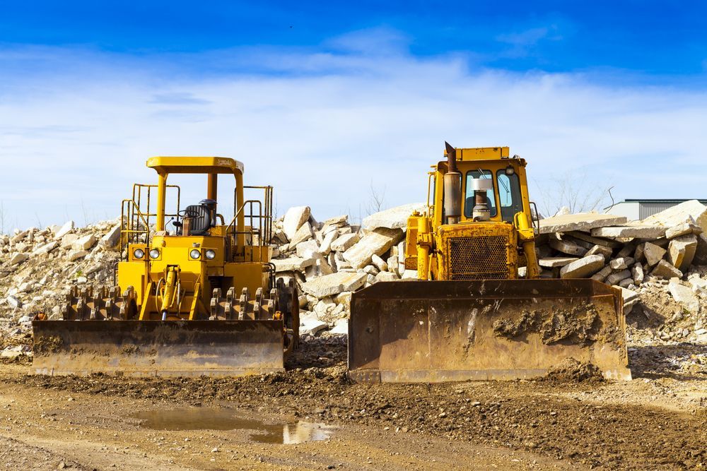 Two Yellow Bulldozers on a Construction Site With Debris — Jim Anderson Earthmoving Pty Ltd In Wingham, NSW