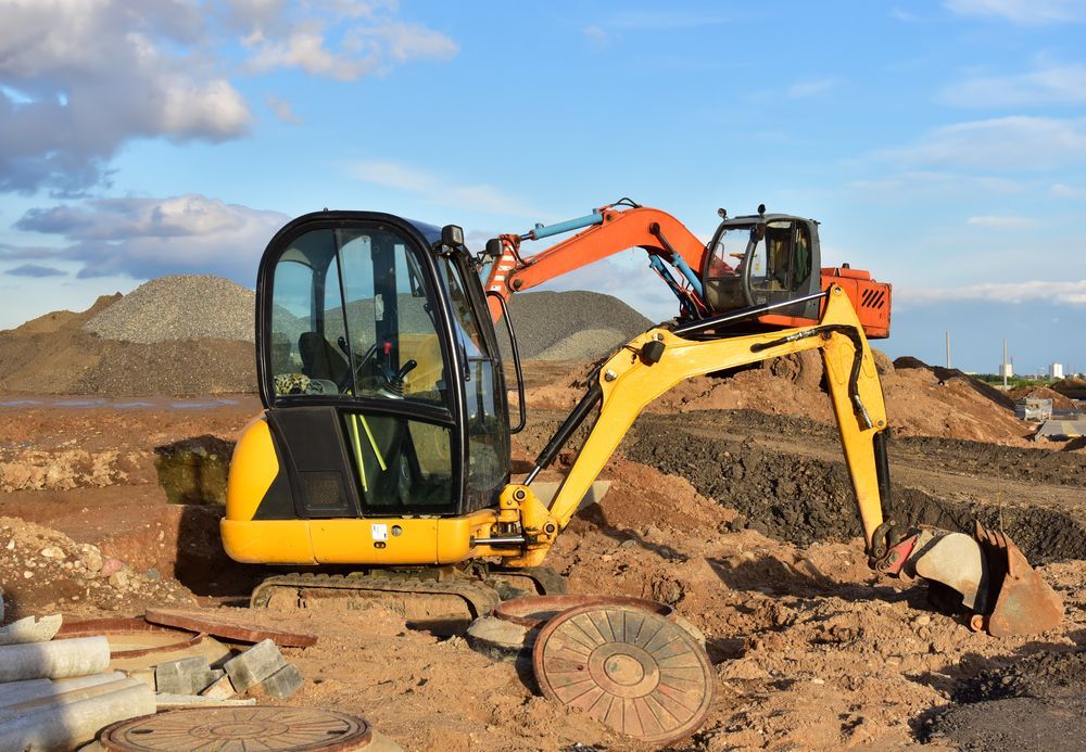 Yellow Excavator on a Dirt Construction Site, Scooping Earth — Jim Anderson Earthmoving Pty Ltd In Old Bar, NSW