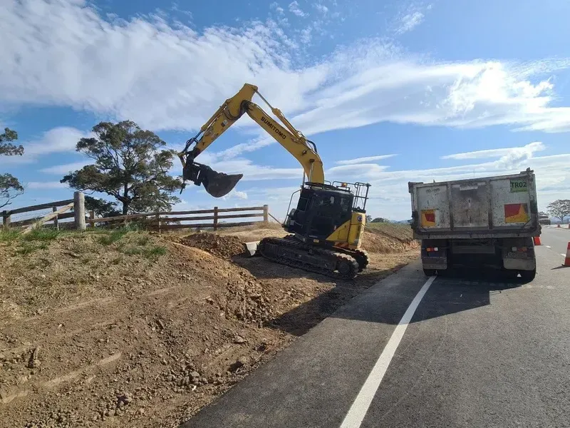 Yellow Excavator Loading Dirt Into a Dump Truck — Jim Anderson Earthmoving Pty Ltd In Harrington, NSW