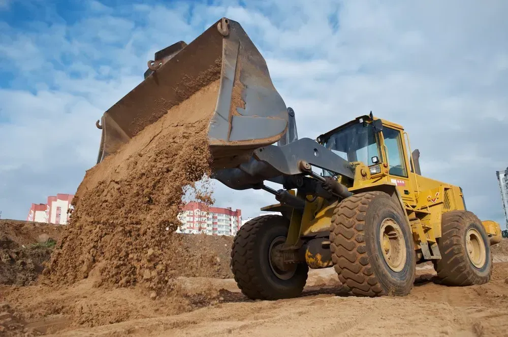 Yellow Front-End Loader Dumping Dirt on A Construction Site — Jim Anderson Earthmoving Pty Ltd in Coopernook, NSW