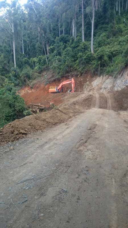 Excavator Working on a Dirt Road Cut Into a Hillside — Jim Anderson Earthmoving Pty Ltd In Bulahdelah, NSW