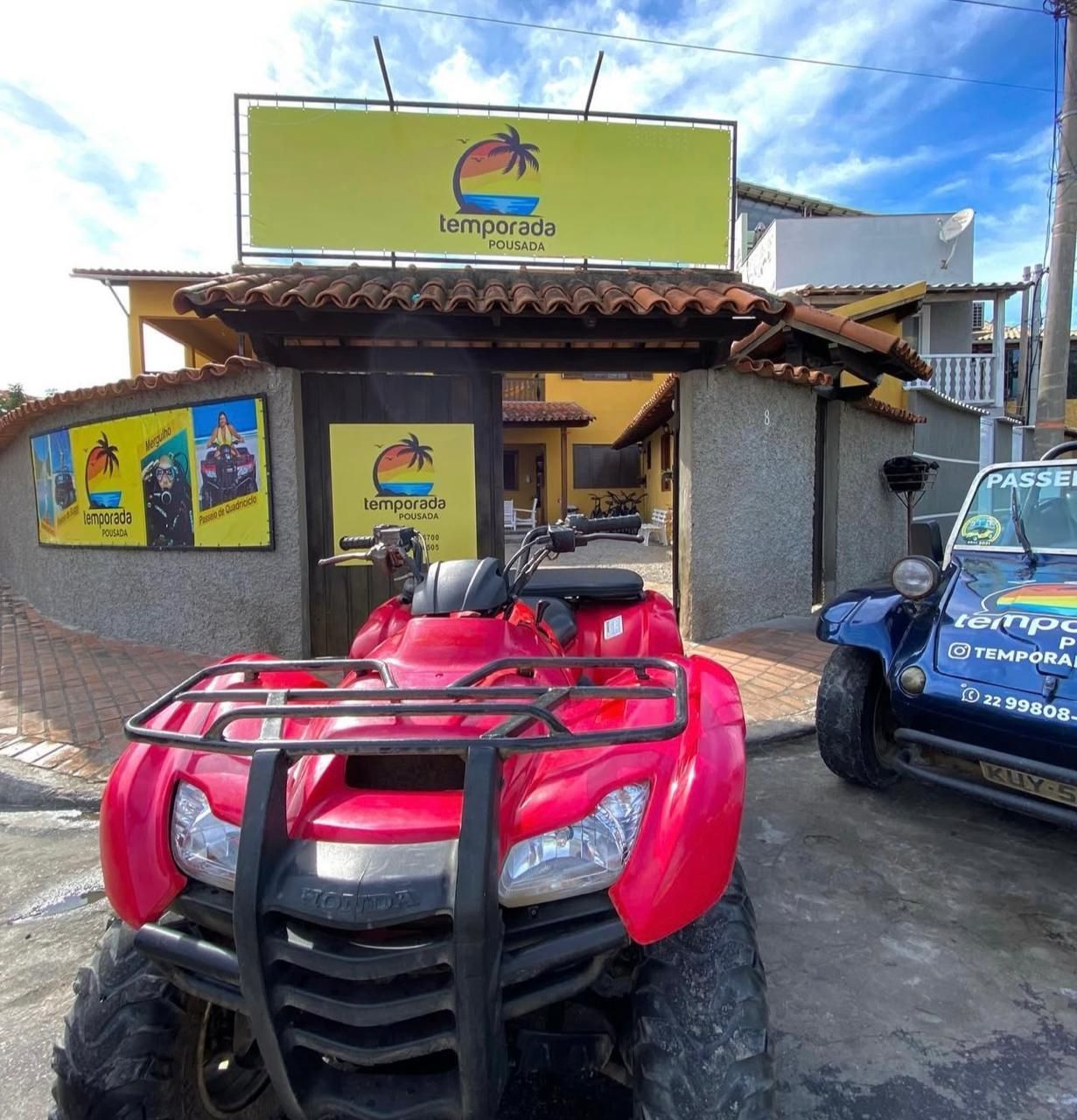 Um quadriciclo vermelho está estacionado em frente a um prédio