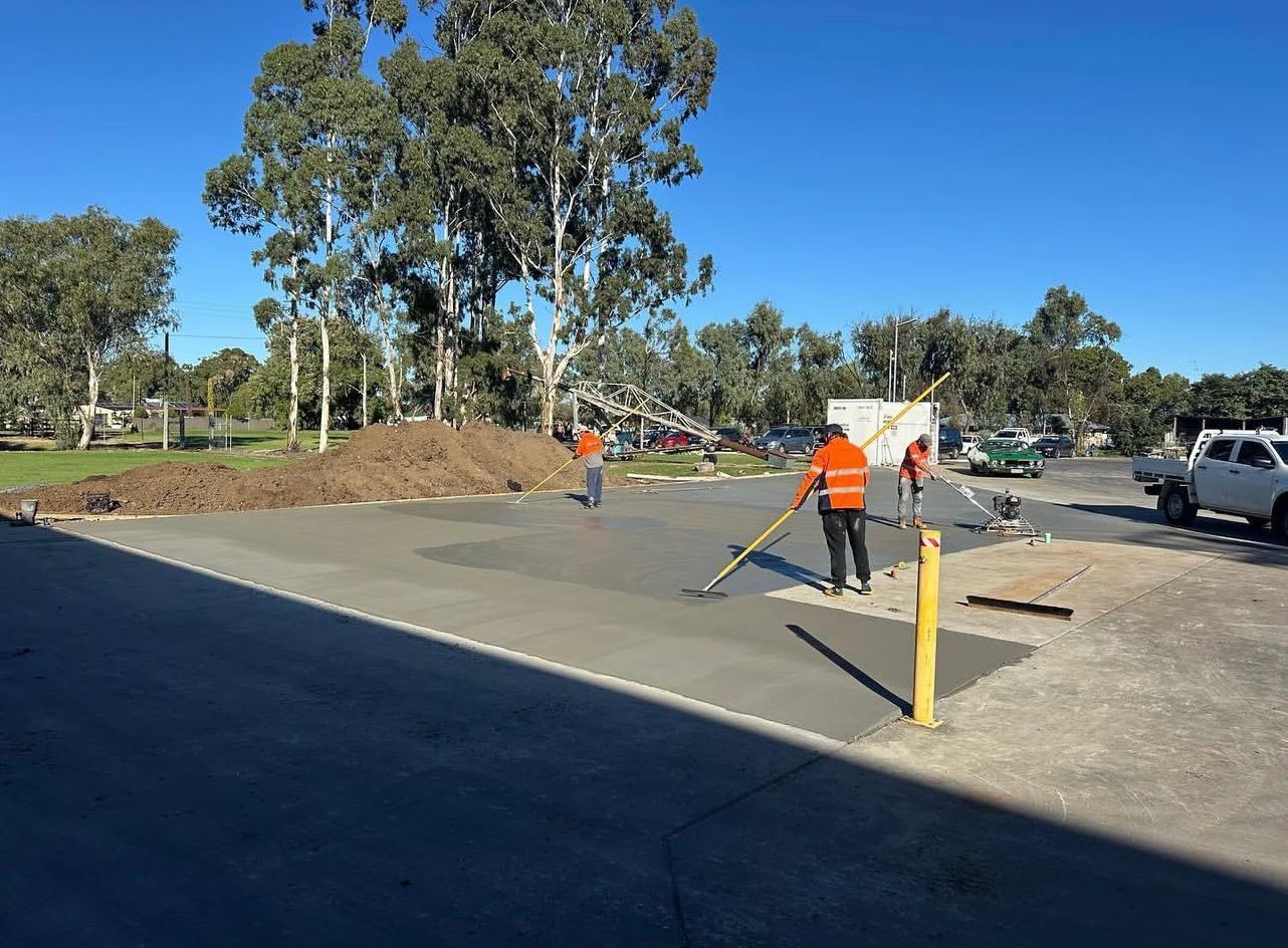 Construction Workers Spreading Wet Concrete on a Parking Lot — Chief Structural Landscaping In Darling Downs, QLD
