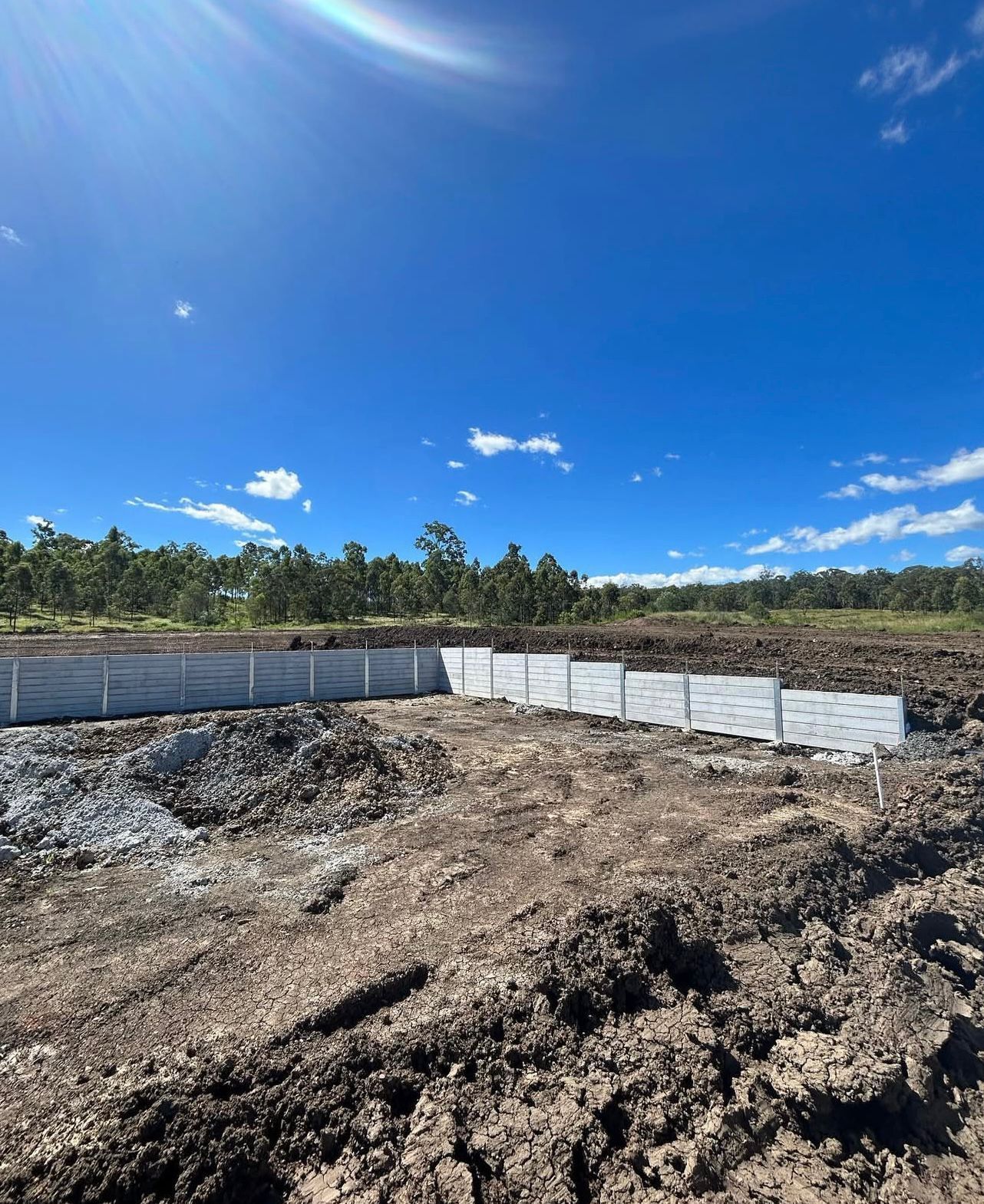 Construction Site With Concrete Retaining Wall Under a Bright Blue Sky — Chief Structural Landscaping In Glenvale, QLD