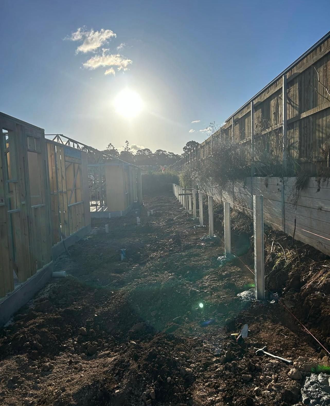 Sunlit Dirt Path Between Fences and Wooden Retaining Walls With Posts — Chief Structural Landscaping In Glenvale, QLD