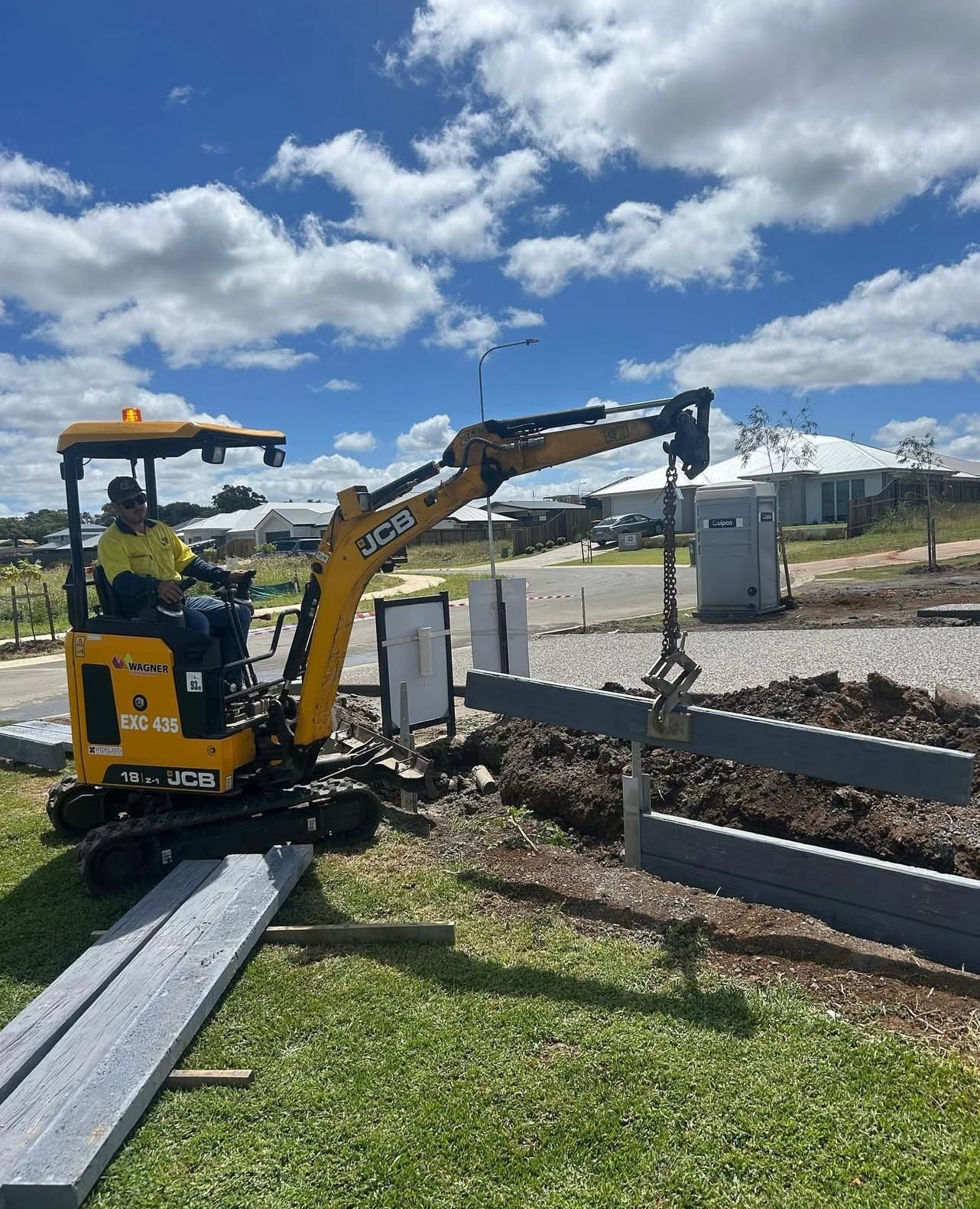 Yellow Excavator Placing Grey Beams on a Construction Site — Chief Structural Landscaping In Gold Coast, QLD