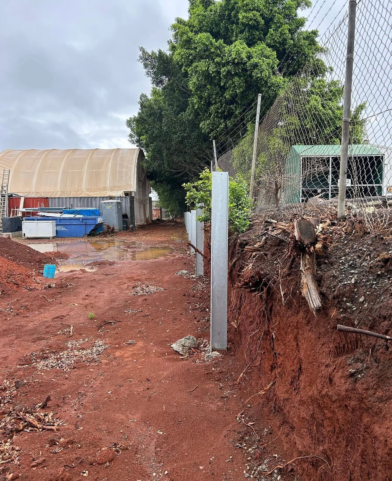 Construction Site With Metal Fence Posts Along a Red Dirt Path — Chief Structural Landscaping In Glenvale, QLD