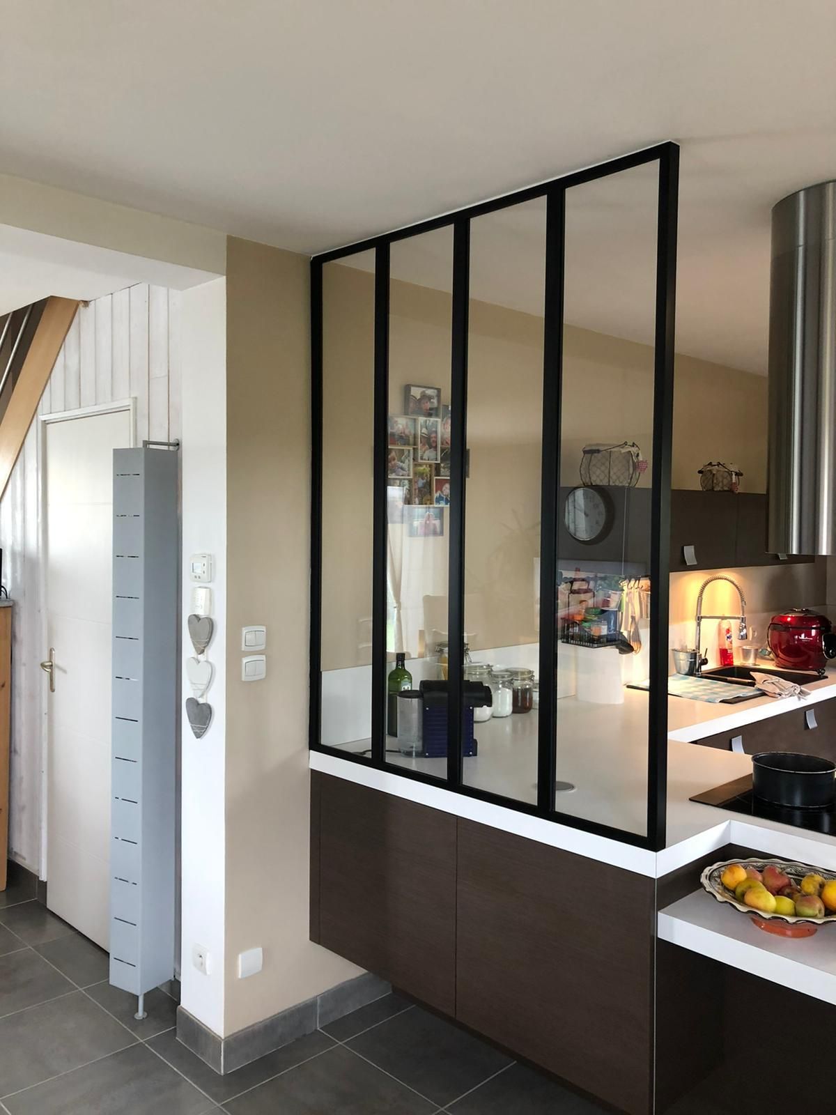 Cuisine avec une cloison en verre à cadre noir séparant la cuisine et le comptoir d'un autre espace.