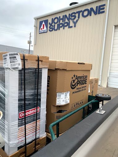A bunch of boxes are sitting in front of a johnstone supply building.