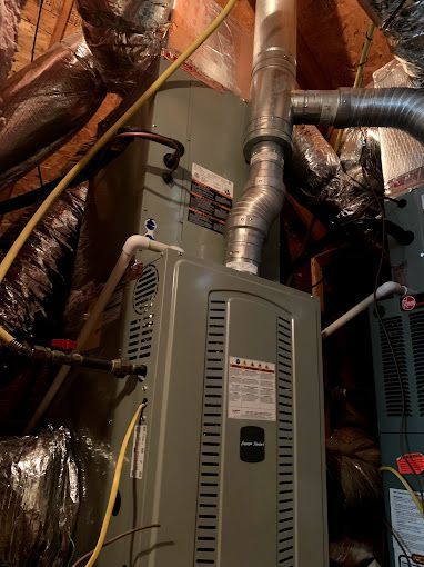 An air conditioner is sitting in the attic of a house.