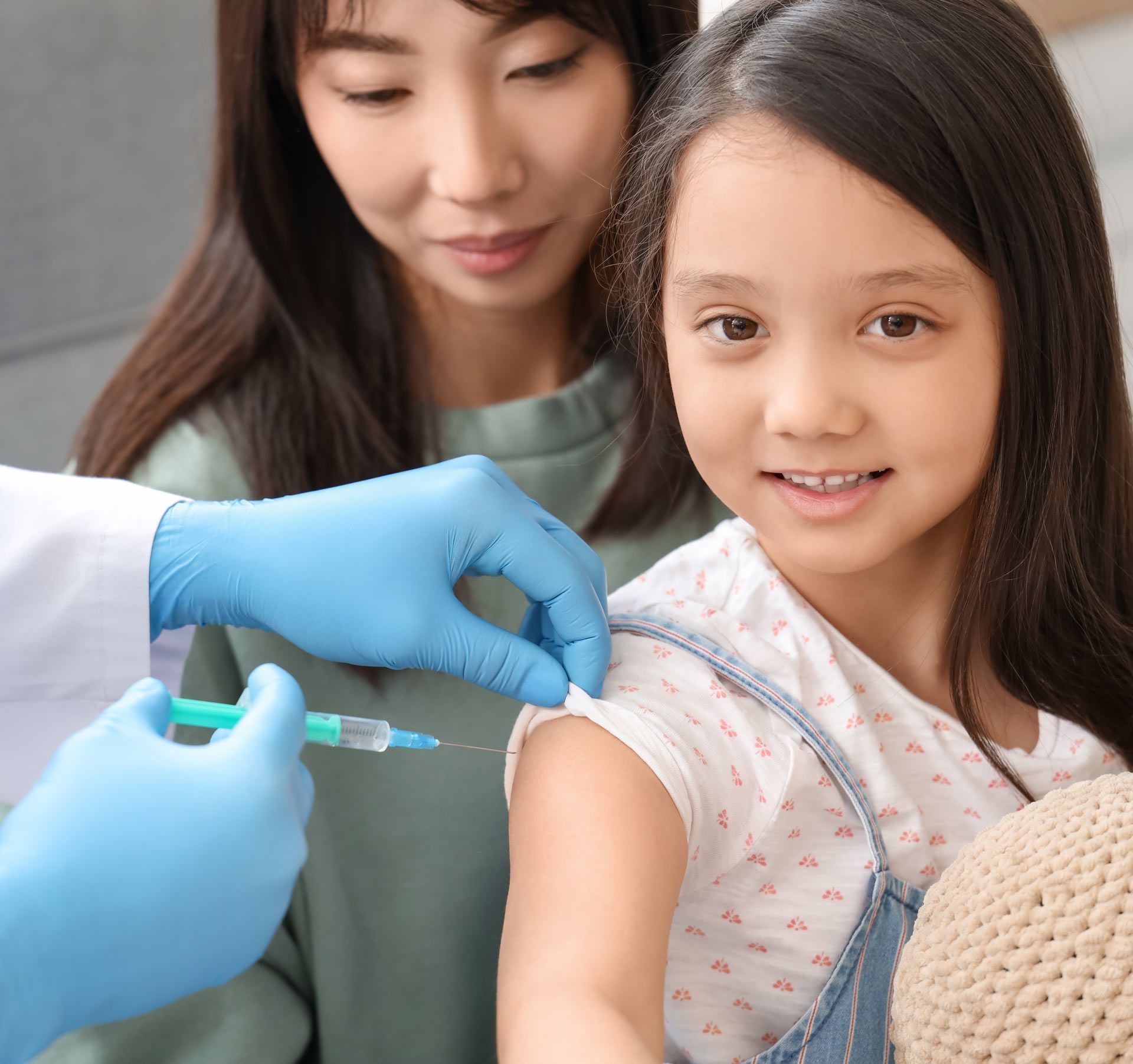 A little girl is getting an injection in her arm