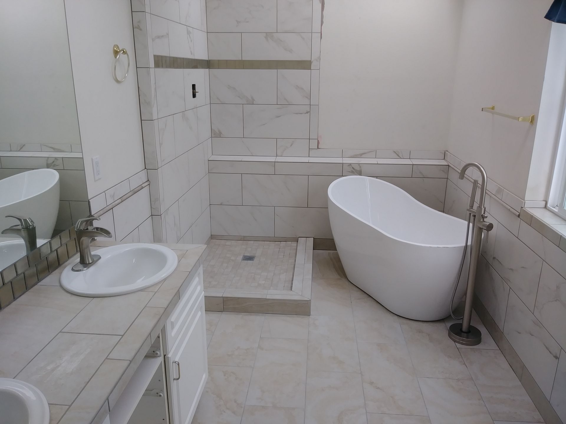 A bathroom with a tub , sink , and shower.