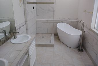 A bathroom with a tub , sink , and shower.