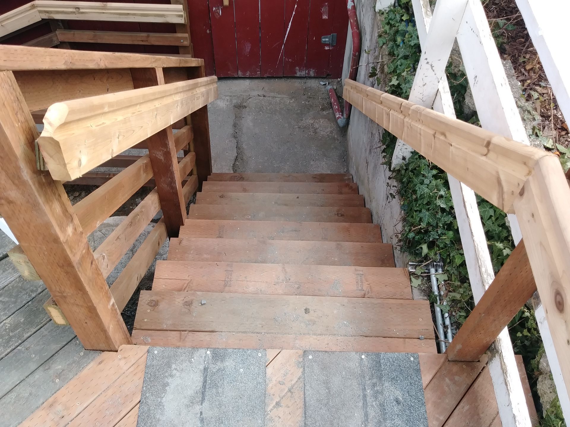 A set of wooden stairs with a white railing