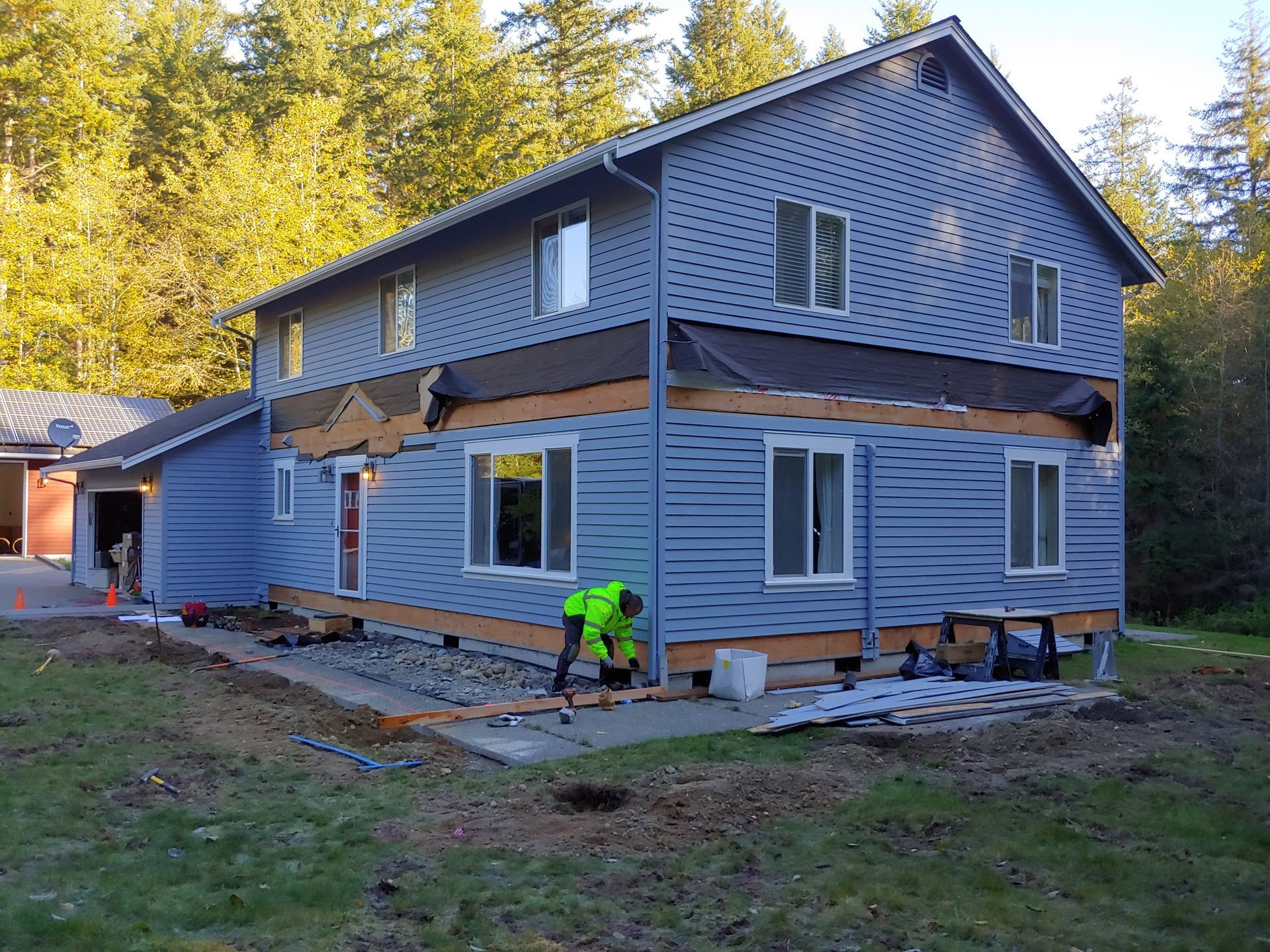 A man is working on the side of a house.