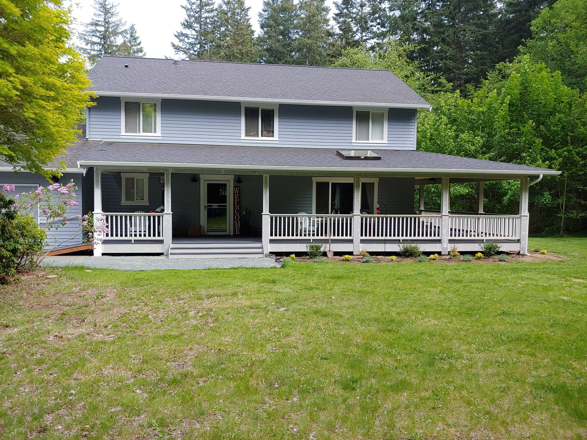 A large house with a large porch and a large lawn in front of it