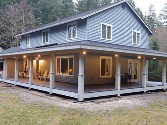 A white house with a wooden deck in front of it