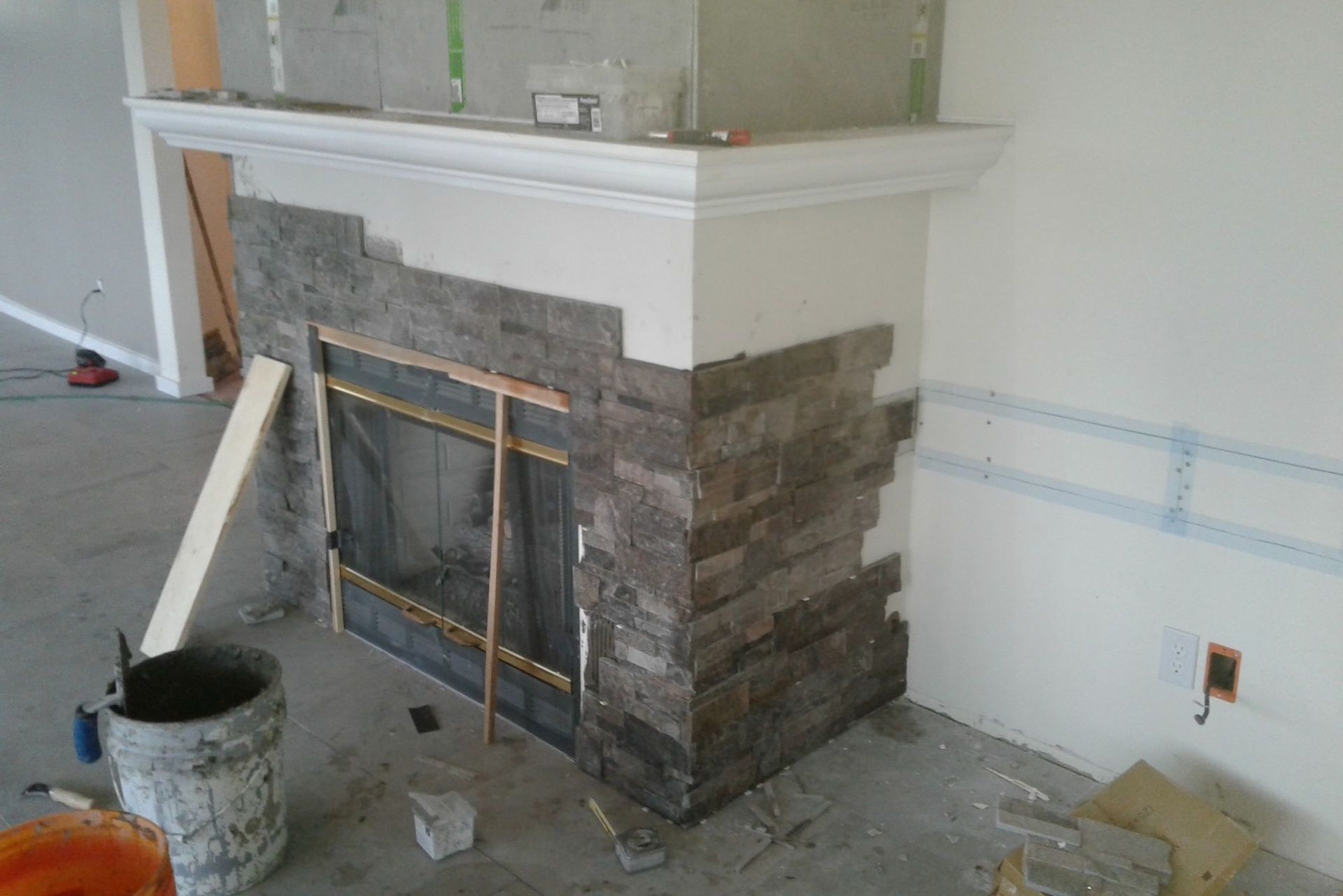 A fireplace is being remodeled in a living room.