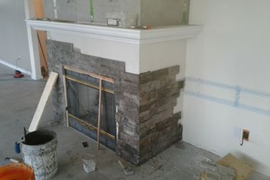 A fireplace is being remodeled in a living room.