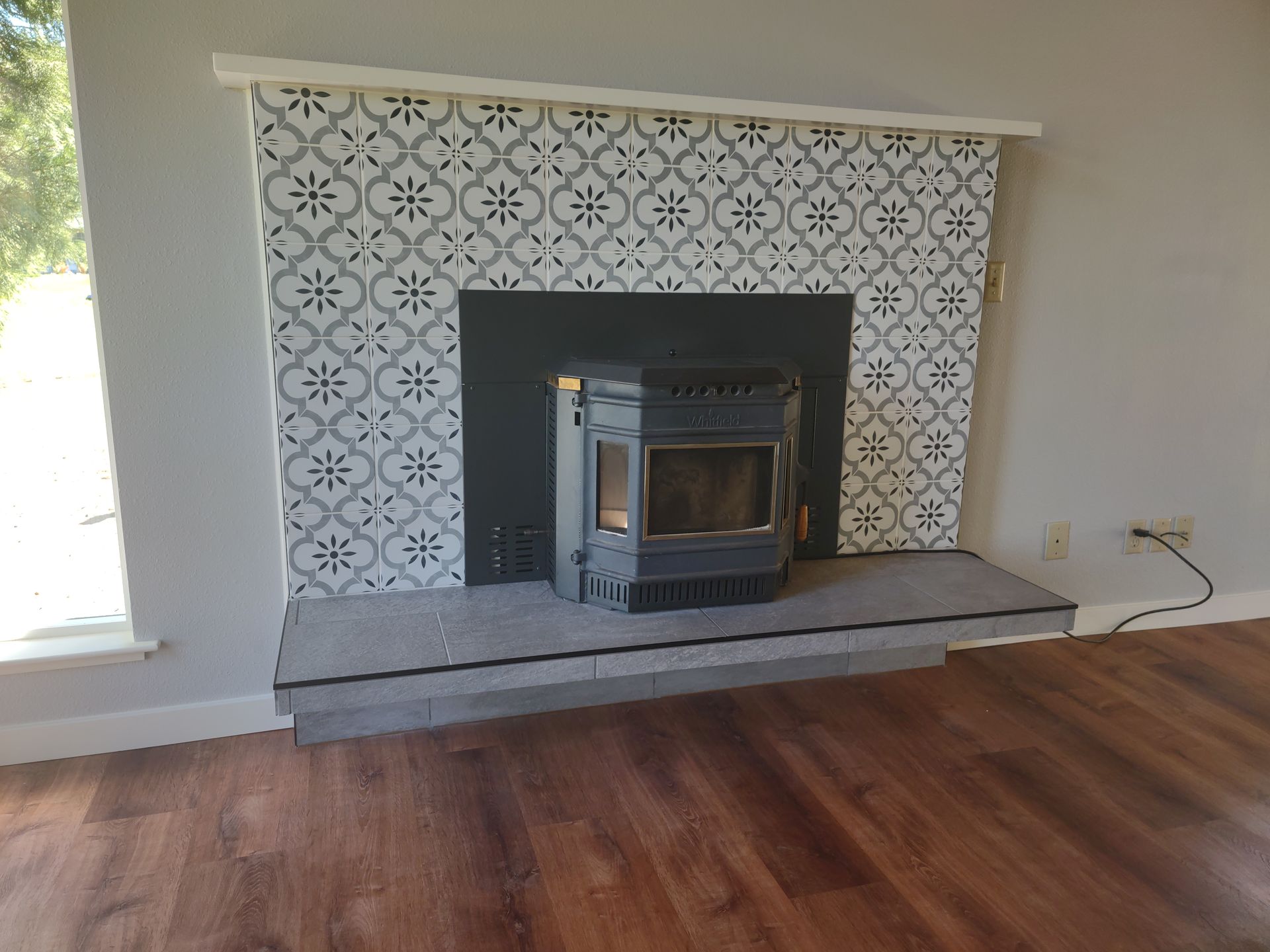 A fireplace with a wood stove built into it in a living room.
