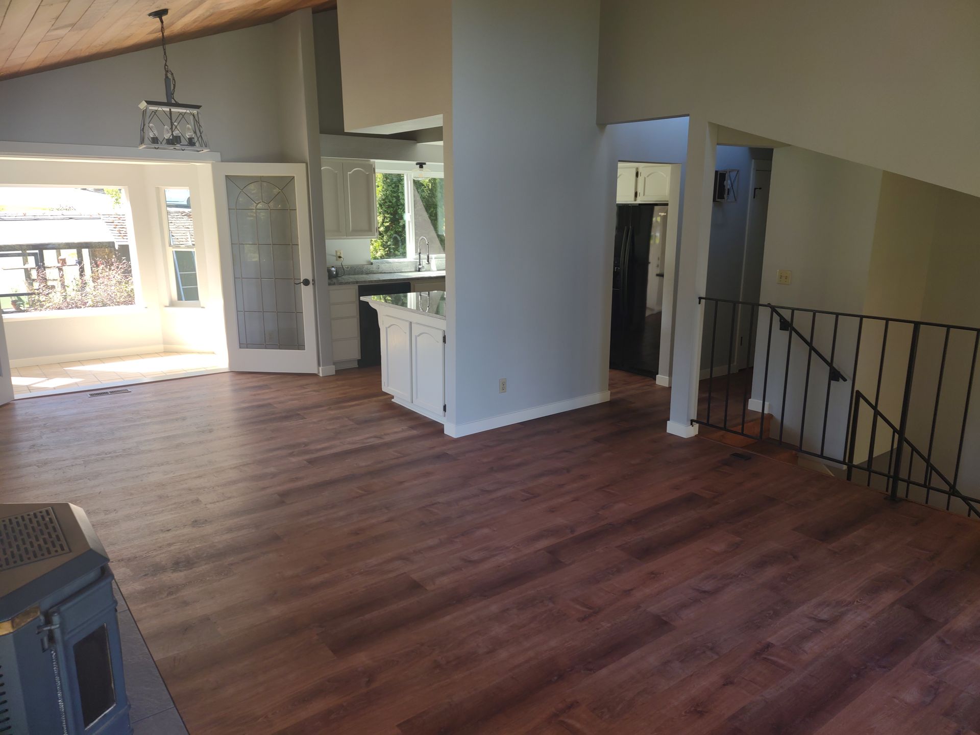 An empty living room with hardwood floors and a staircase leading to the second floor.