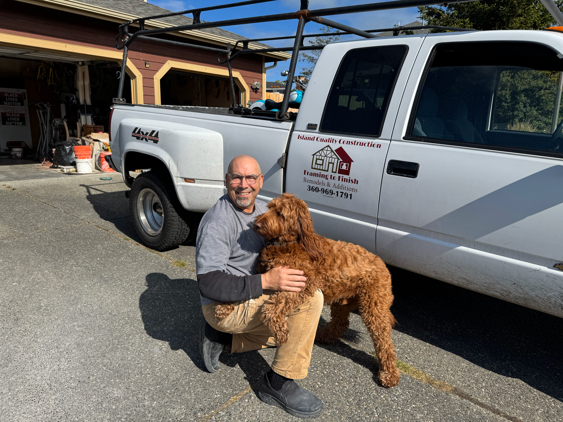 A man and a brown dog are posing for a picture