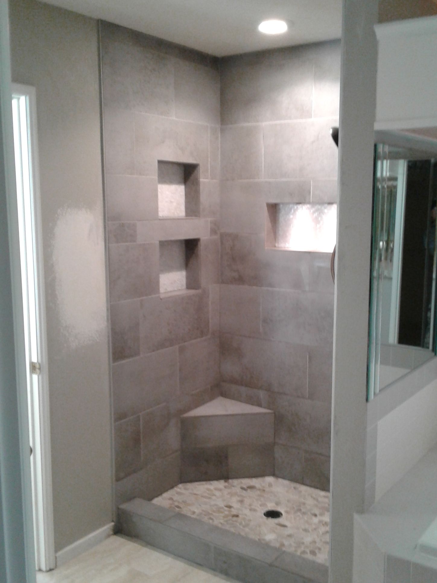 A bathroom with a walk in shower and a sink.