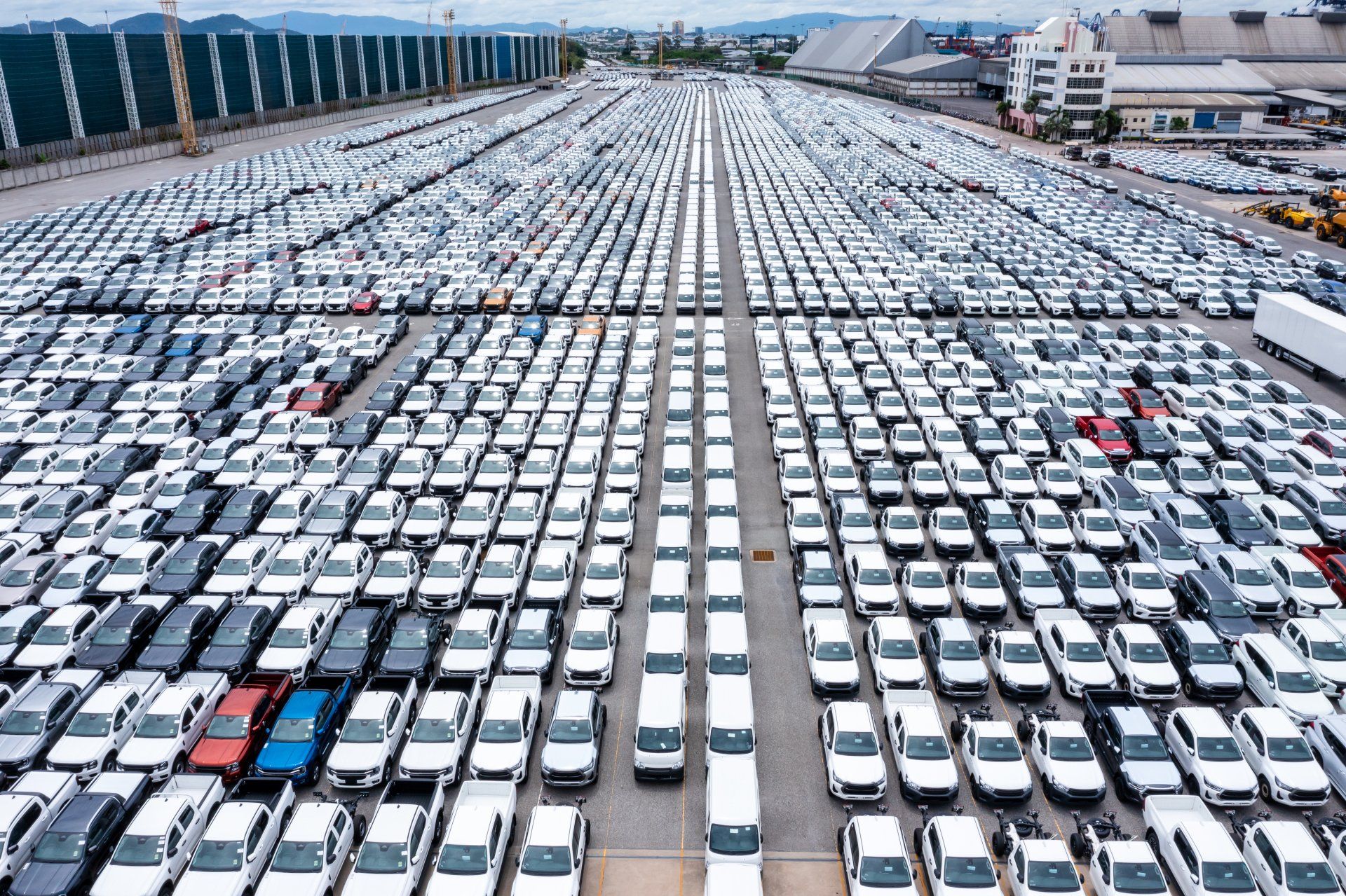 Filas de autos nuevos estacionados en el almacén de la fábrica para distribuidores que comercian