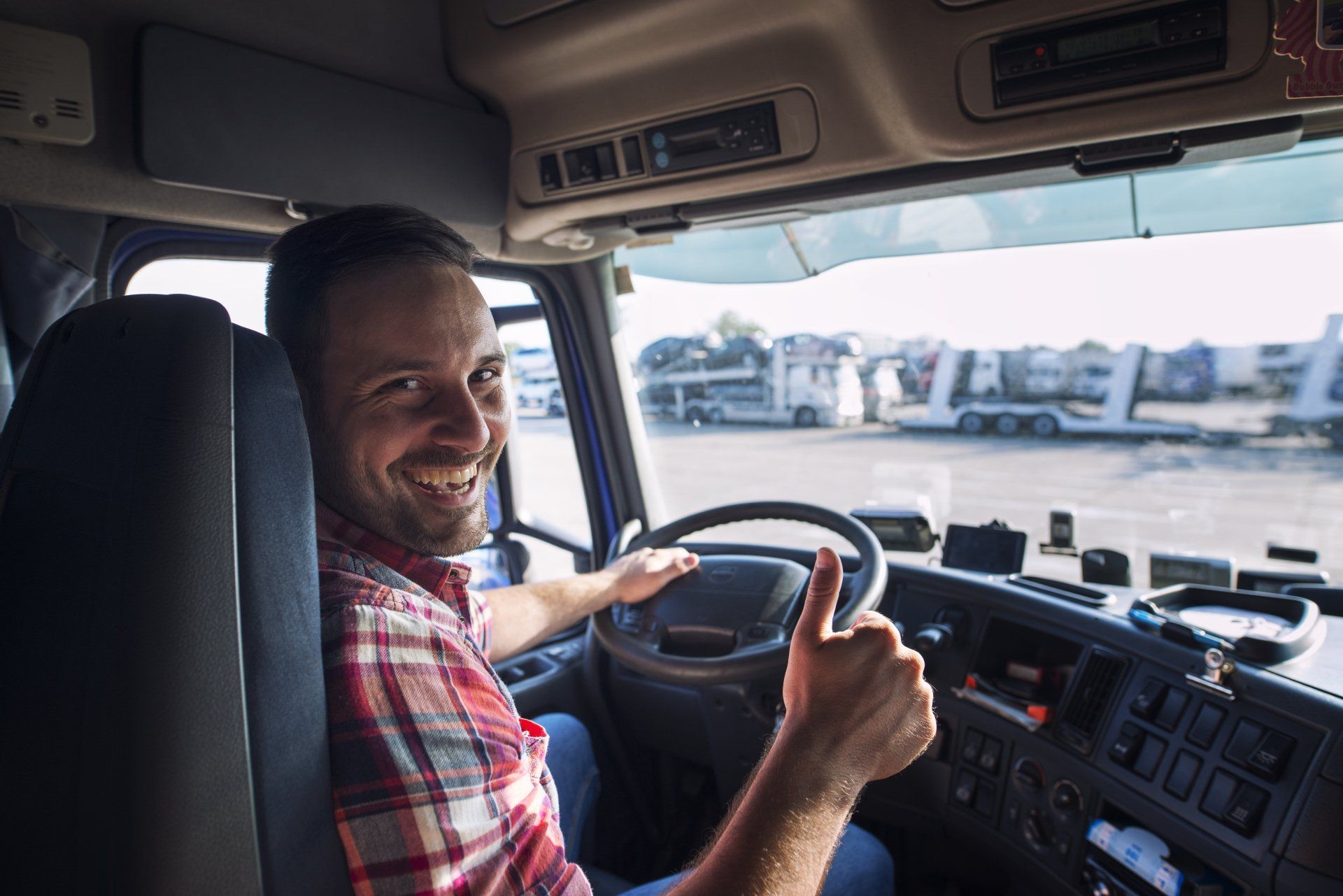 Retrato de conductor de camión sentado en su camión sosteniendo thumbs up