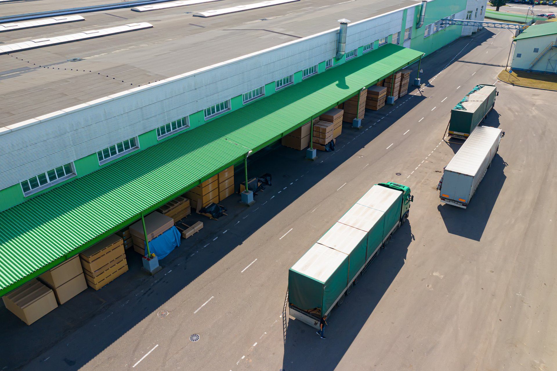 Múltiples camiones cargando en la vista superior de fábrica comercio internacional