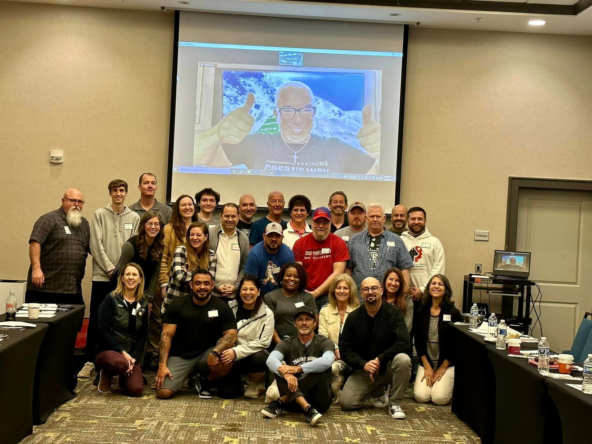 A group of people are posing for a picture in front of a projector screen.