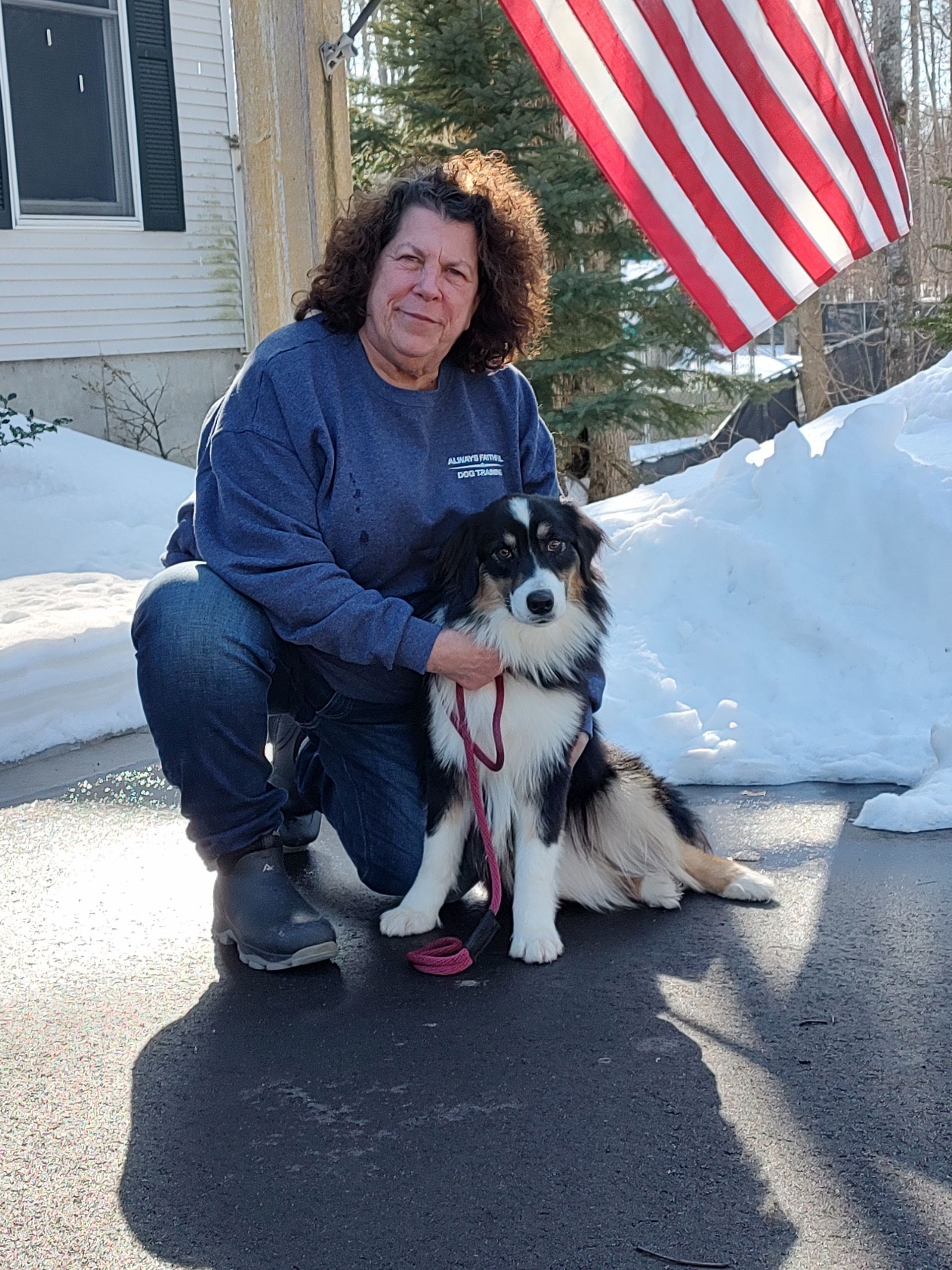 A man standing next to a brown and white dog