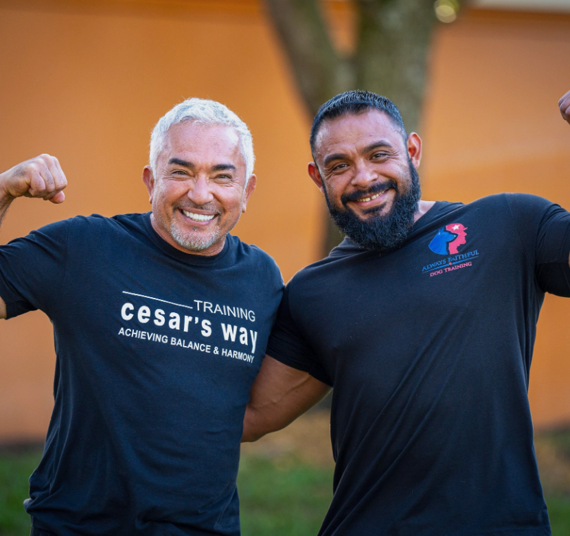 Two men wearing black shirts that say training cesar 's way