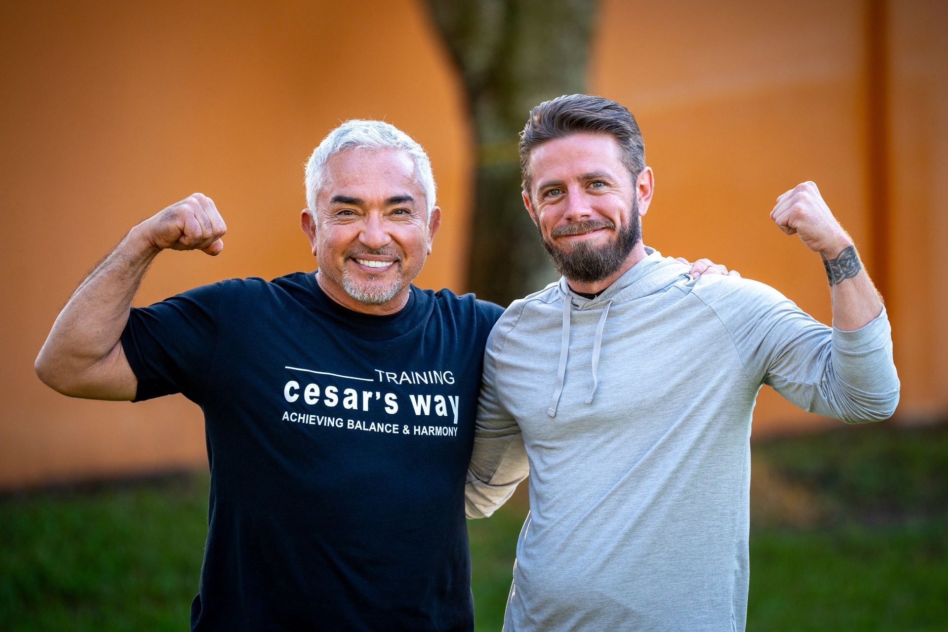 Two men are standing next to each other and flexing their muscles.