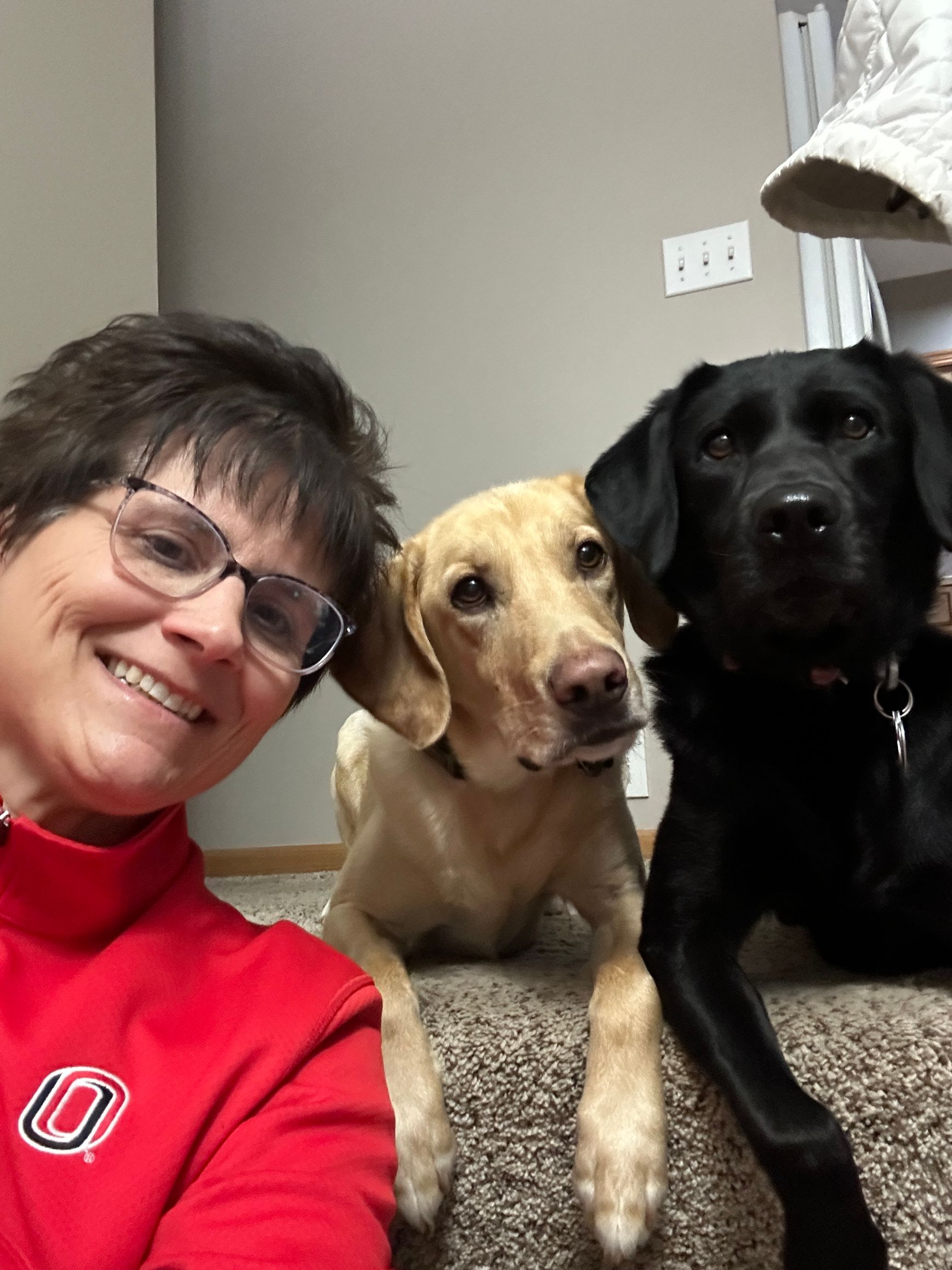 A woman wearing glasses takes a selfie with her dog