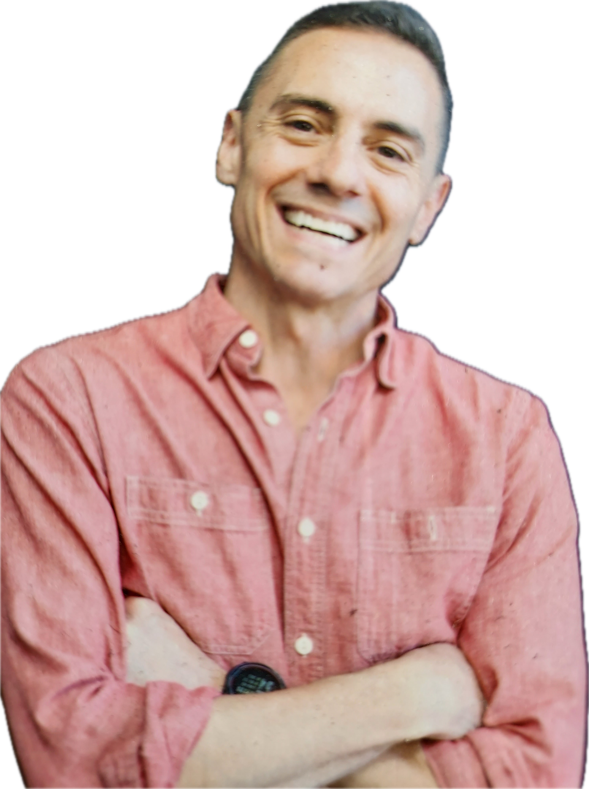 Man in a pink button-down shirt smiles with arms crossed.