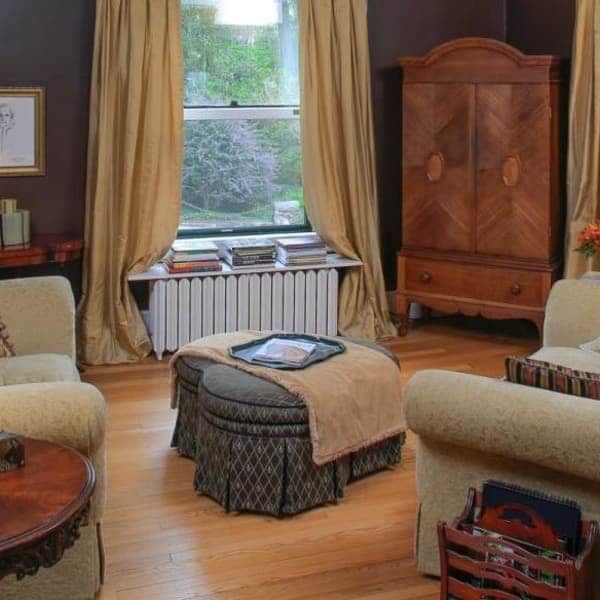 Living room with yellow curtains, wooden cabinet, and cozy furniture.