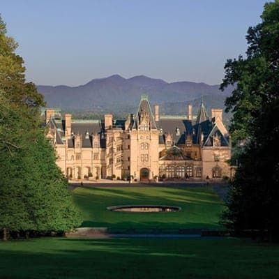 Biltmore Estate, Asheville, North Carolina, viewed from a grassy lawn, with mountains in the background.
