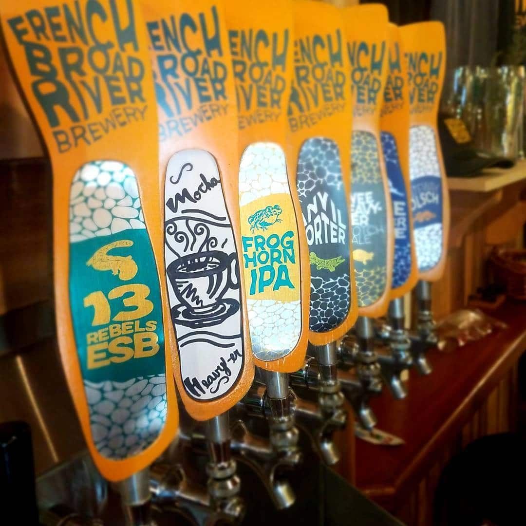 Beer taps with colorful designs from French Broad River Brewery.
