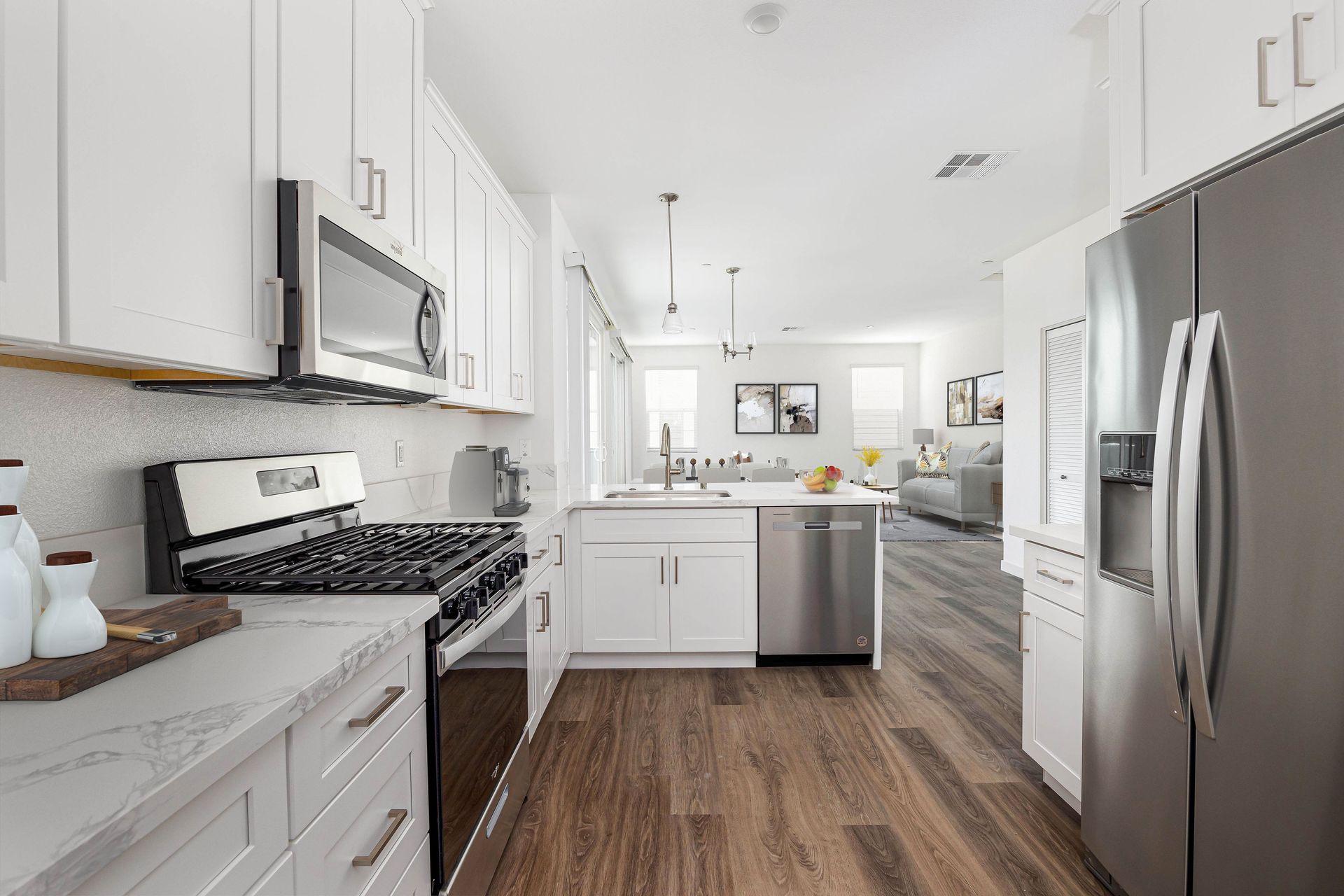 a kitchen with white cabinets and stainless steel appliances .