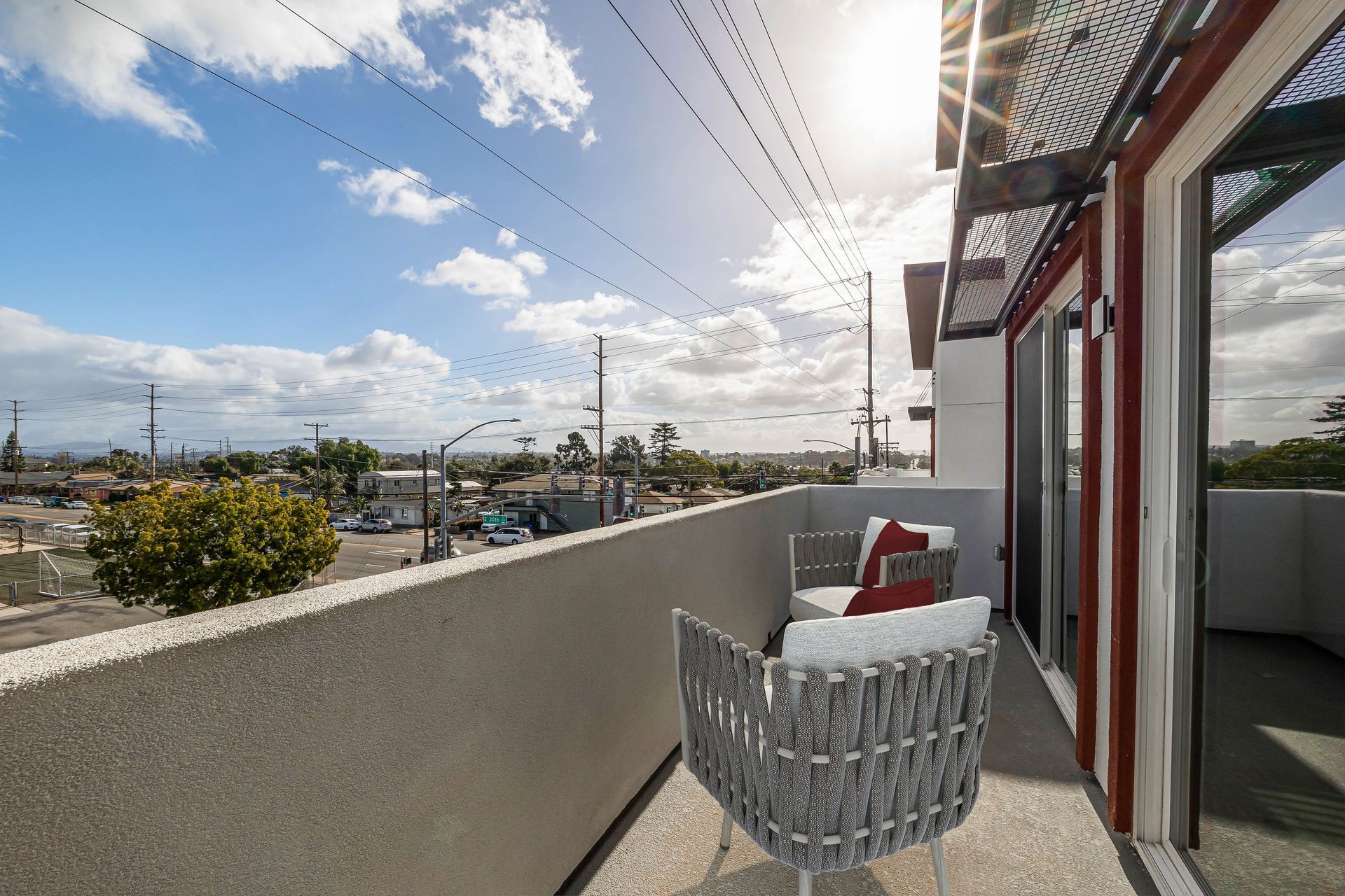 a balcony with a chair and a table with a view of a city .
