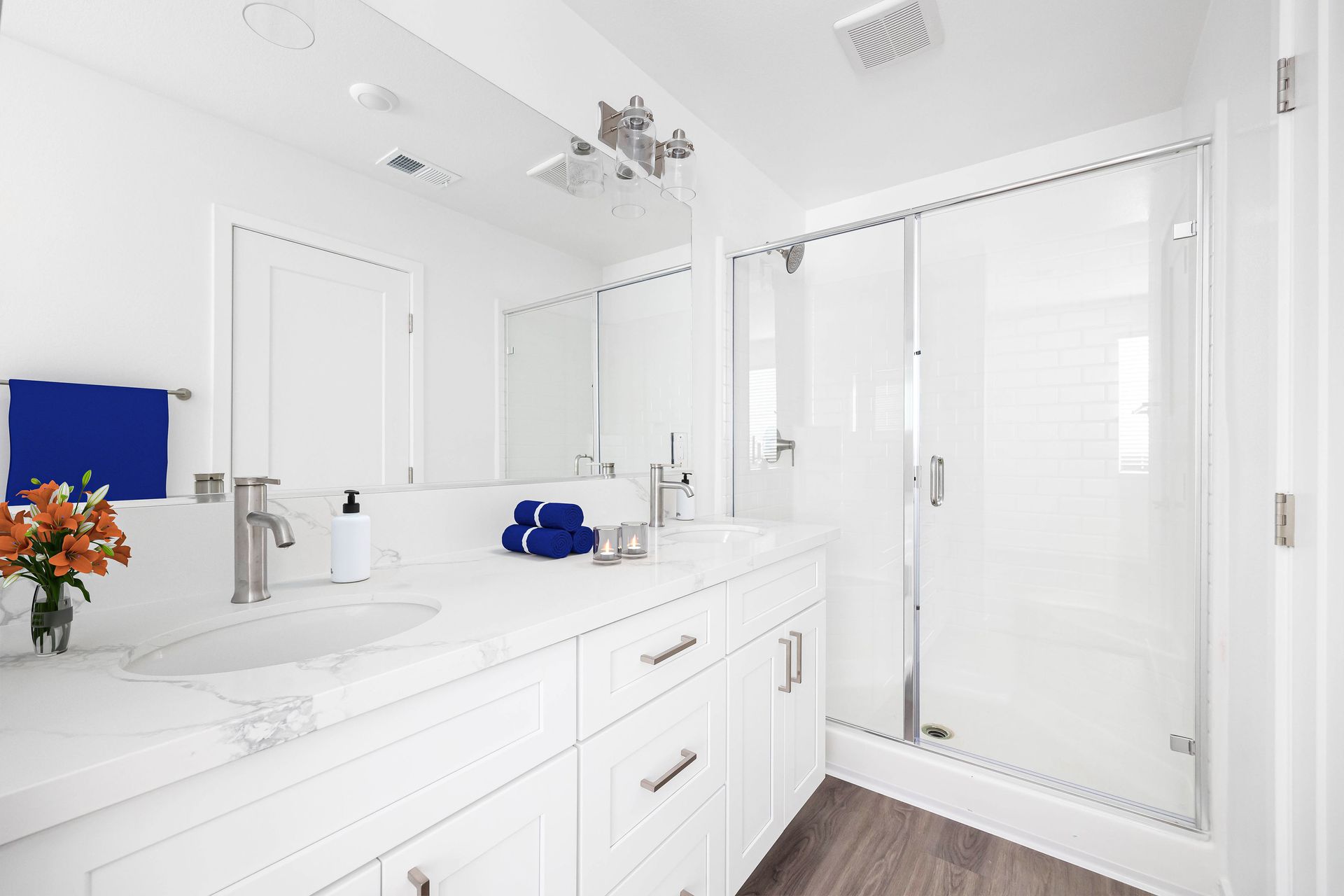 a bathroom with a sink , mirror and shower .