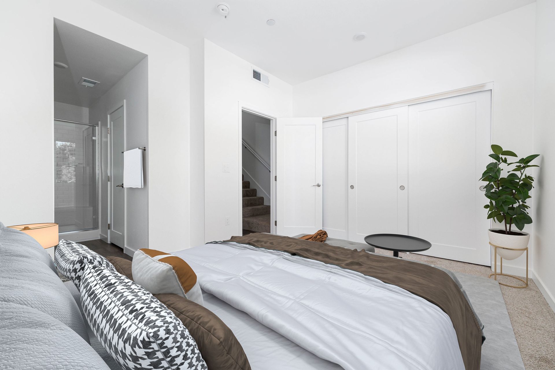 a bedroom with a large bed and a walk in shower .