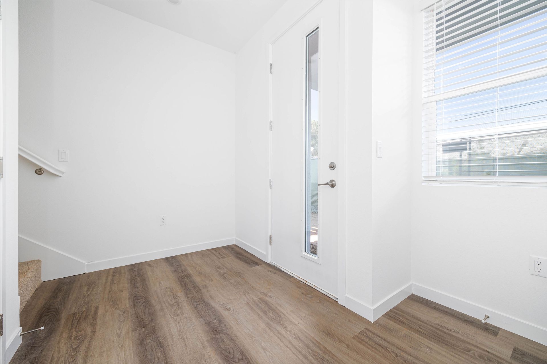 an empty room with hardwood floors and stairs in a house .