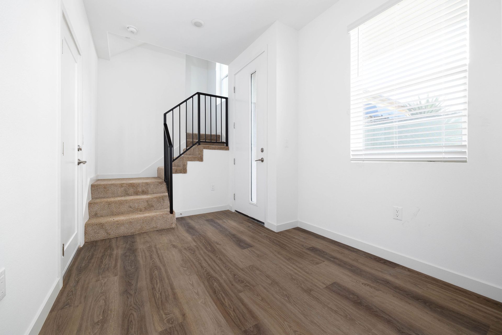 an empty room with hardwood floors and stairs in a house .