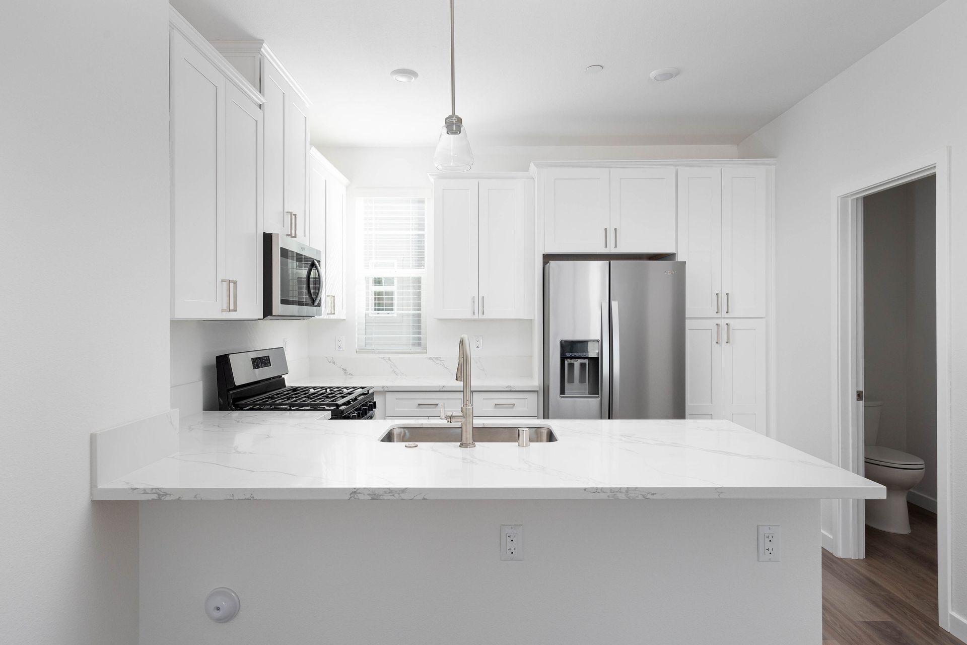 a kitchen with white cabinets and a stainless steel refrigerator .
