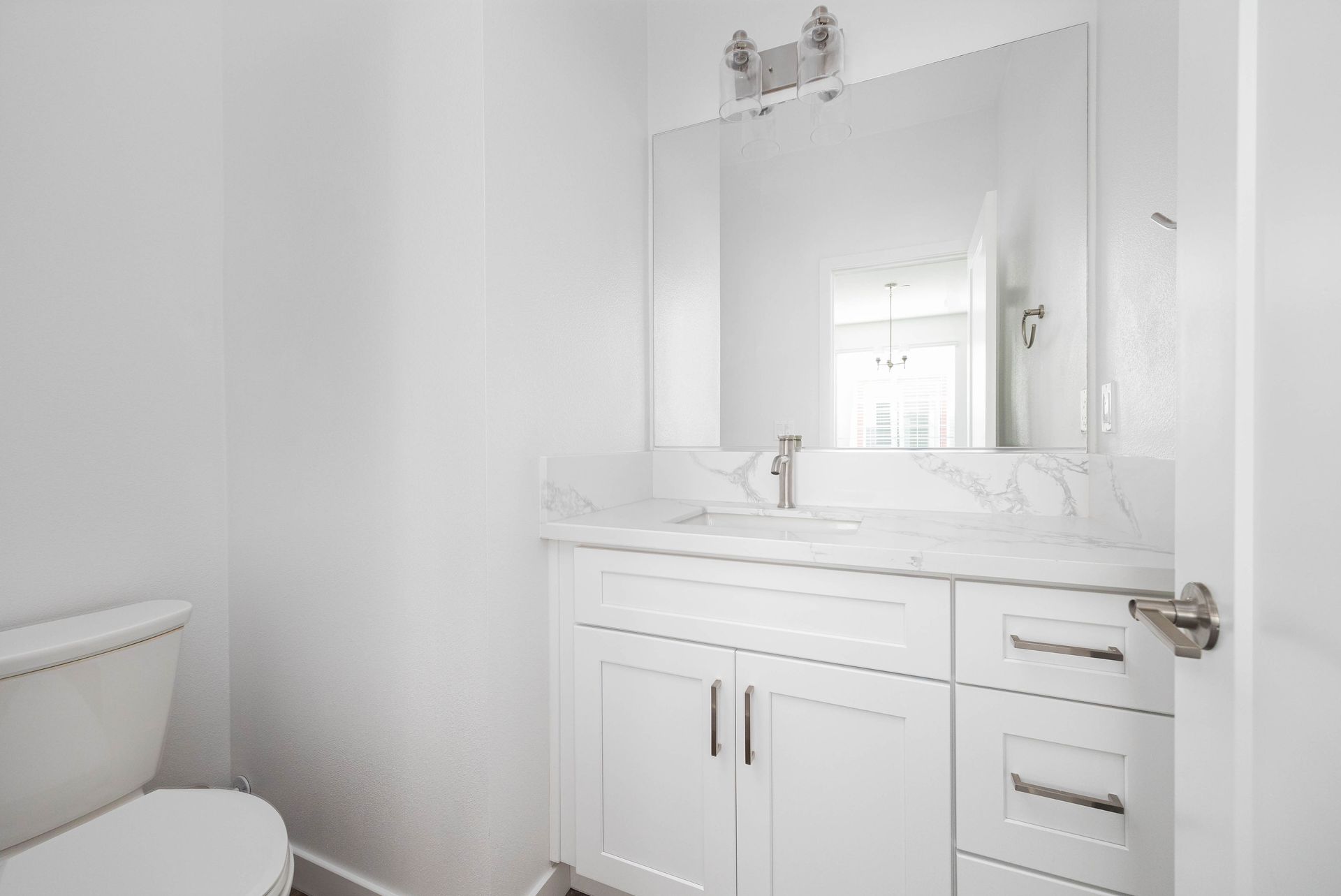 a bathroom with a toilet , sink and mirror .